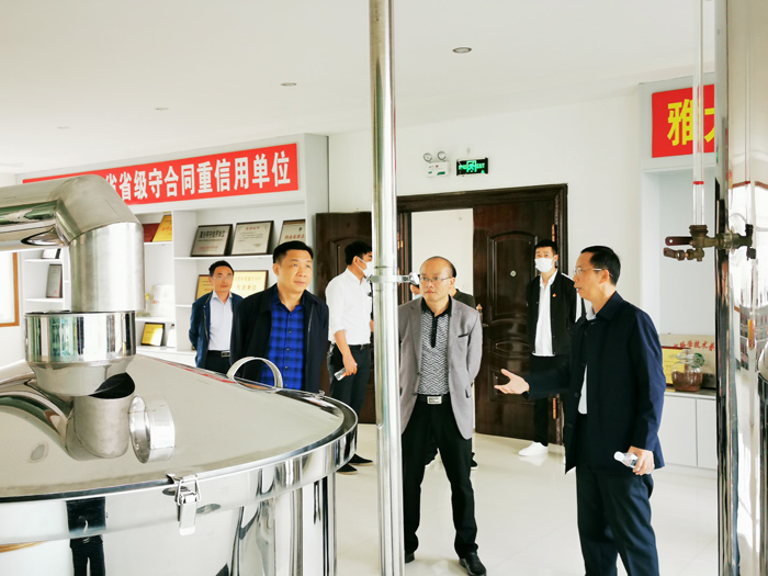 9雅大黨支部書記胡順開向寧勇華一行介紹雅大釀酒設備